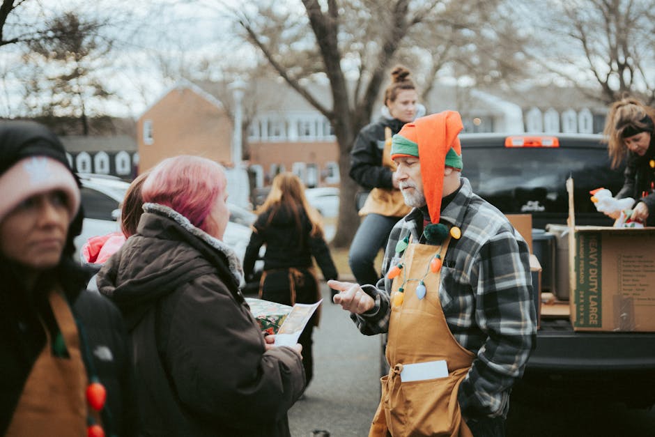 Volunteers hand out gifts during a community Christmas celebration outdoors.